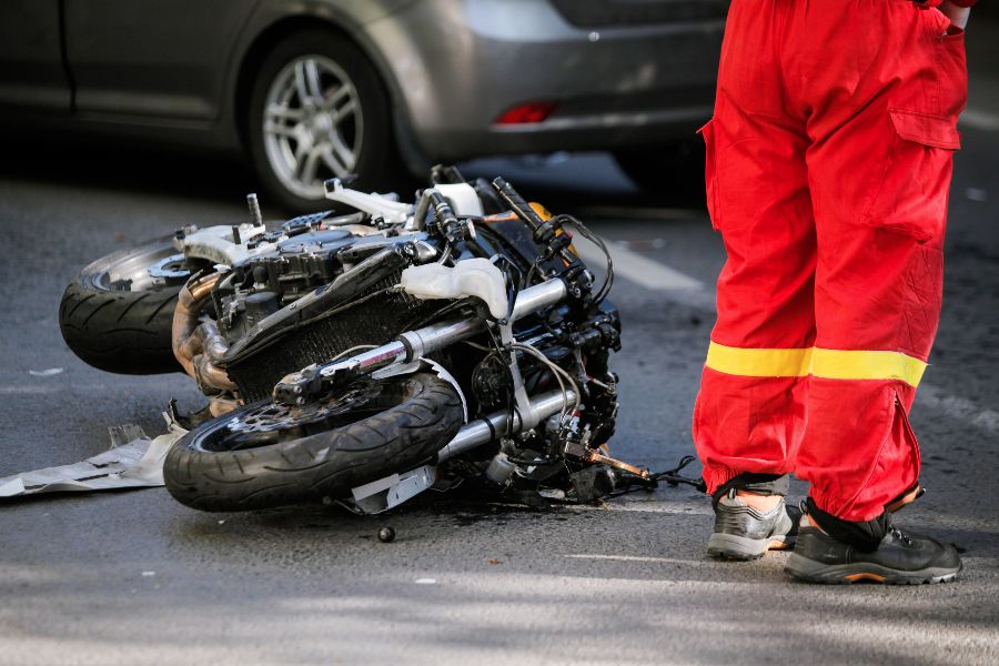 A crashed motorcycle next to an emergency worker